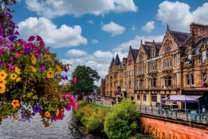 Victorian-era buildings line a busy street in Inverness, Scotland during summer